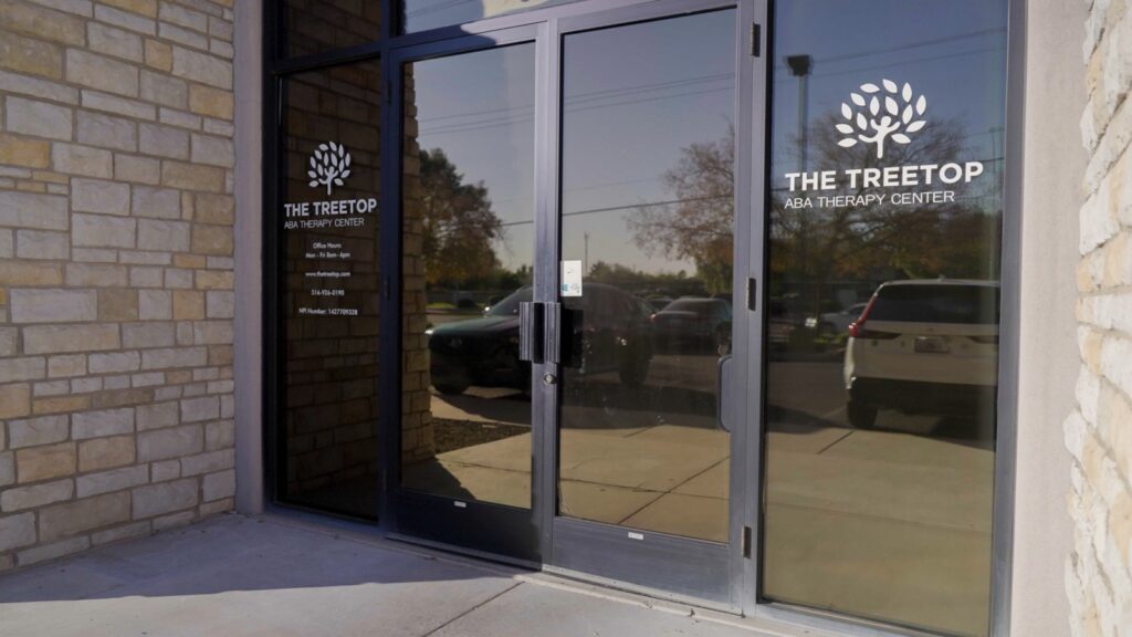 Treetop ABA Therapy Center glass door showing logo and office hours