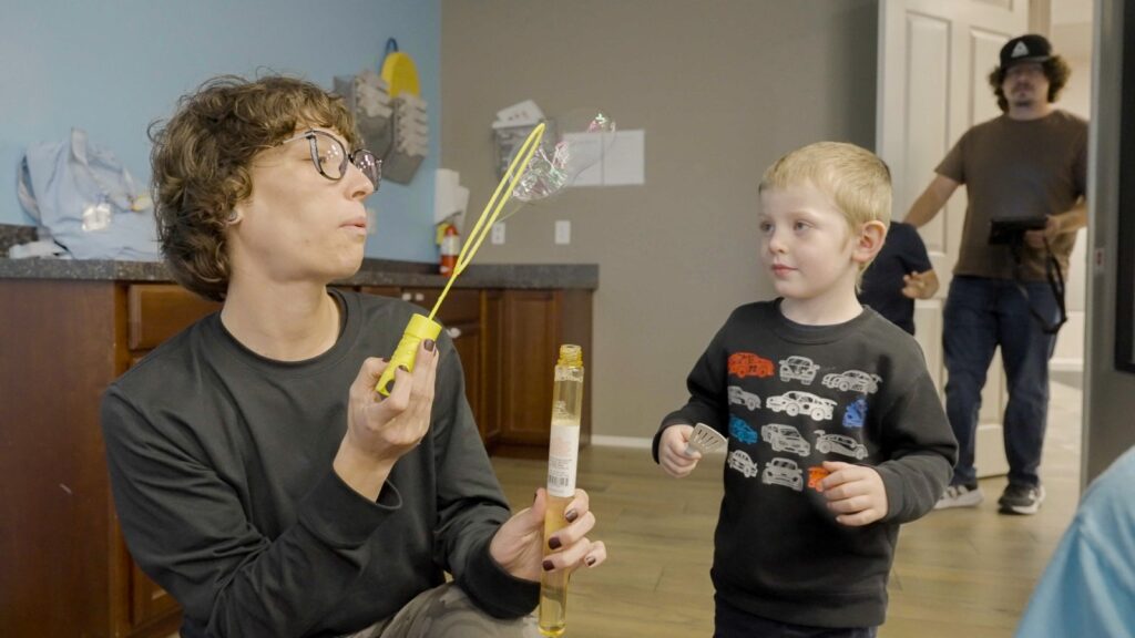 Treetop ABA therapist blowing bubbles during a fun therapy activity with a child