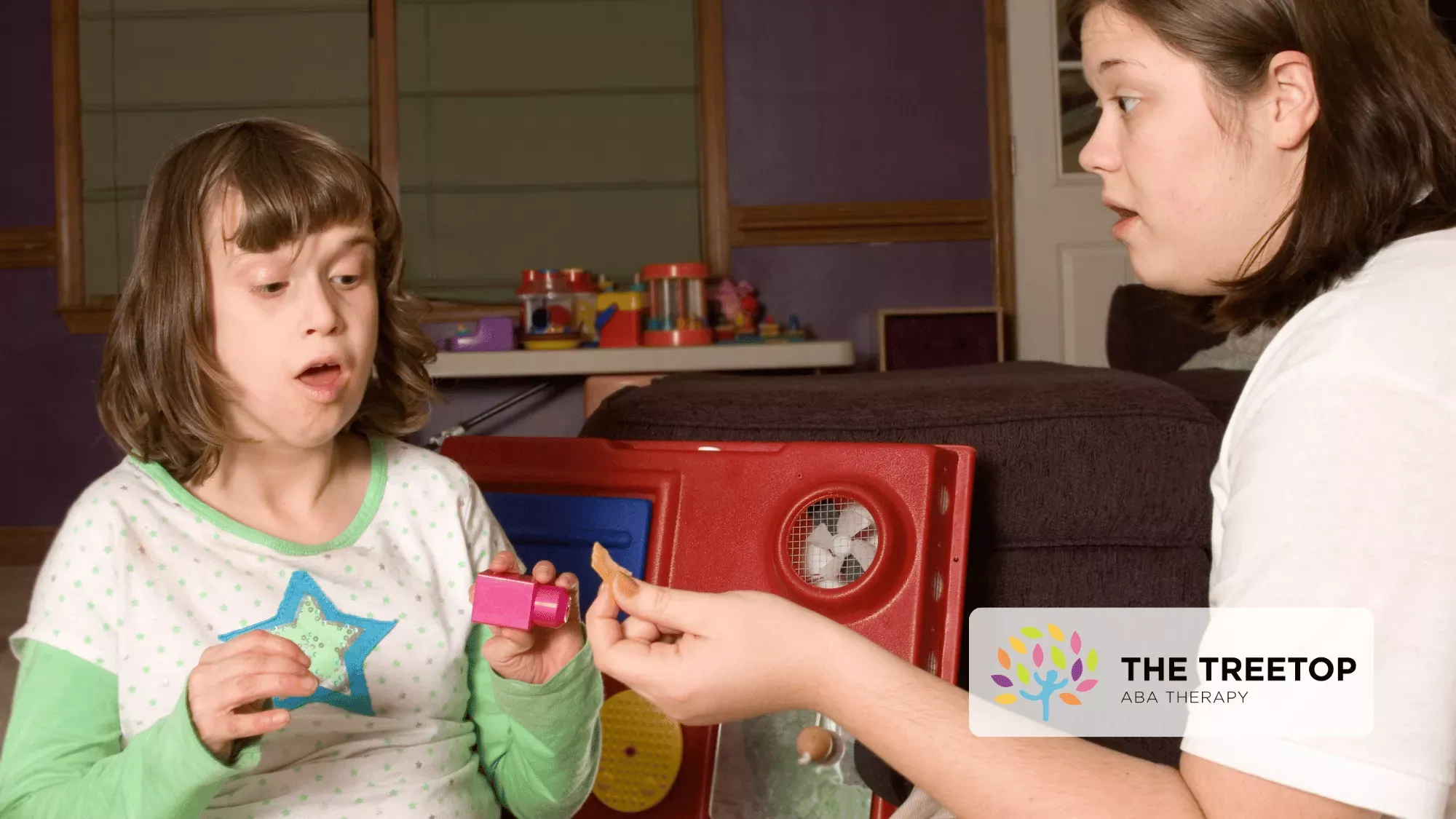 An instructor works with a person on an interactive activity at a table.