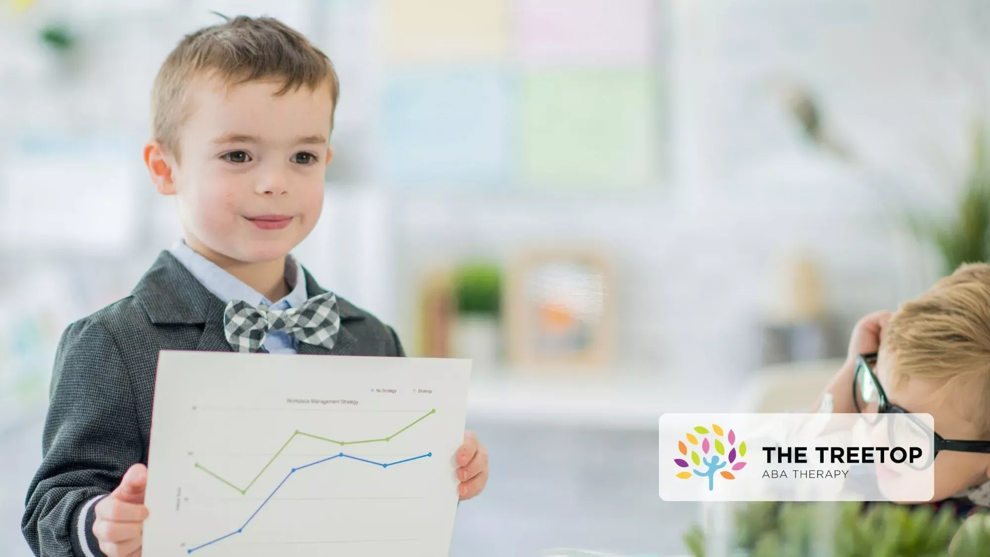 Child holding a chart in a bright classroom, presenting a rising line graph